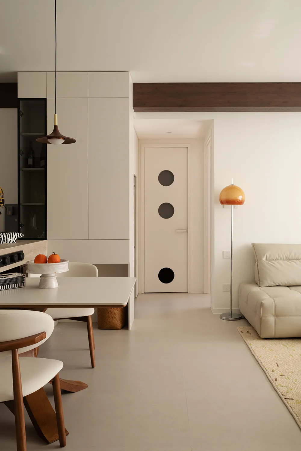 Modern minimalist living and dining room featuring concrete tiles and wood finishes.