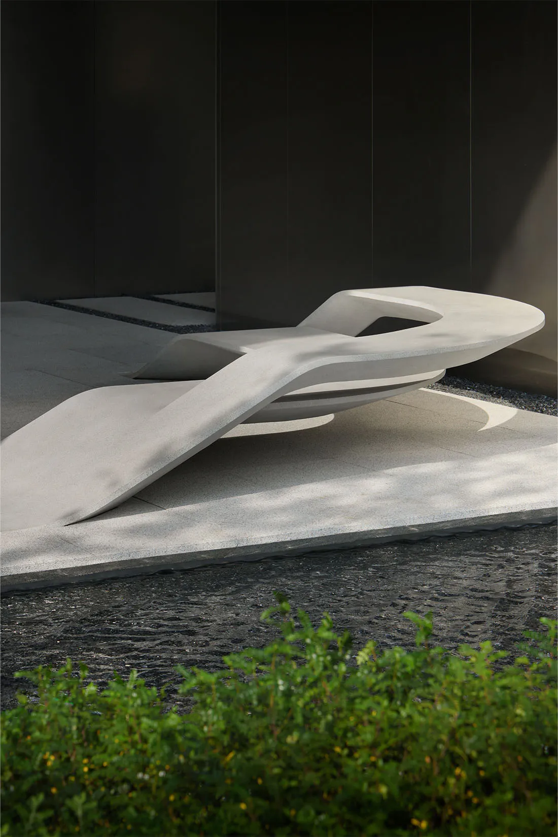Modern bench with abstract, sculptural design in concrete material