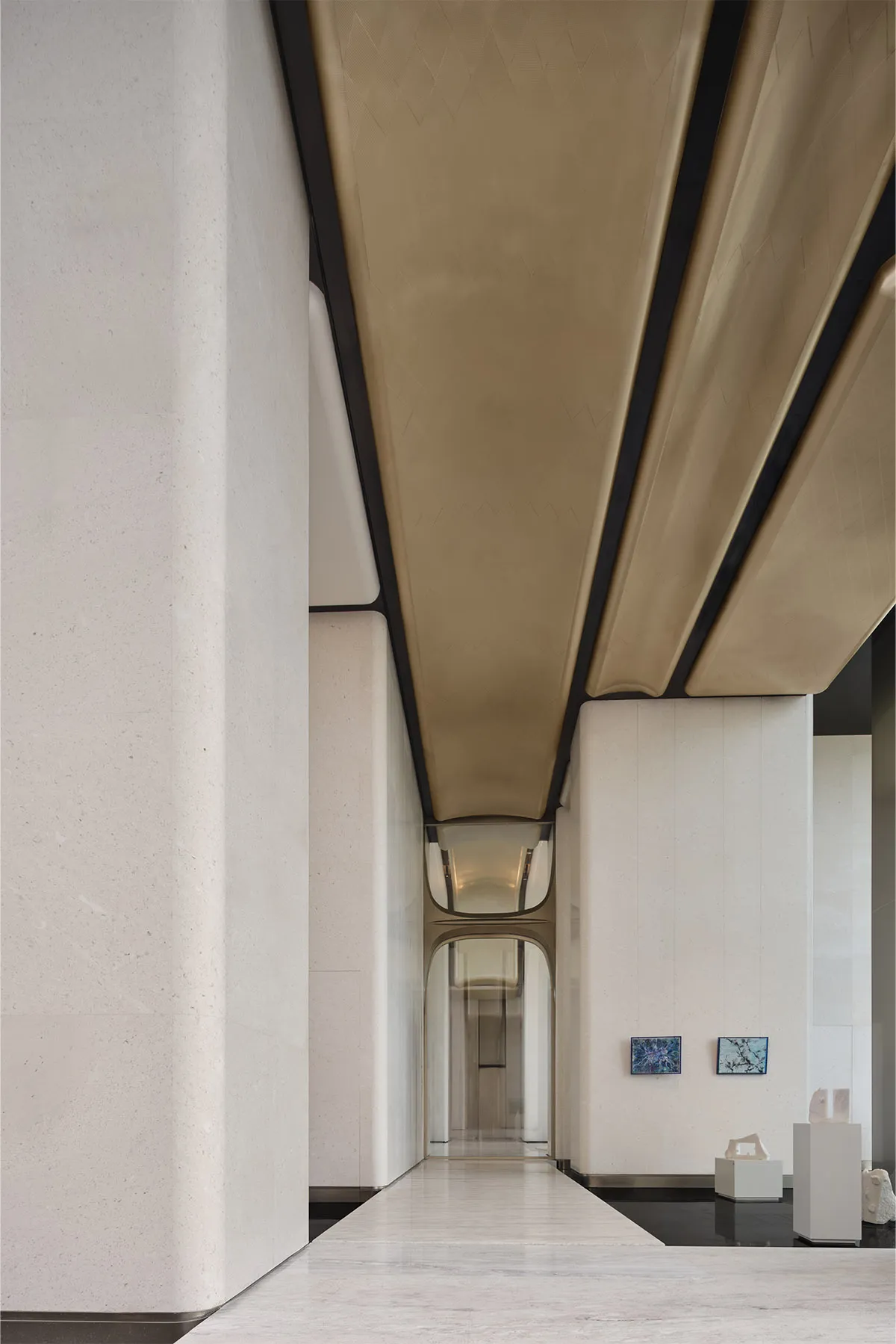 A modern lobby with concrete walls and a white marble floor.