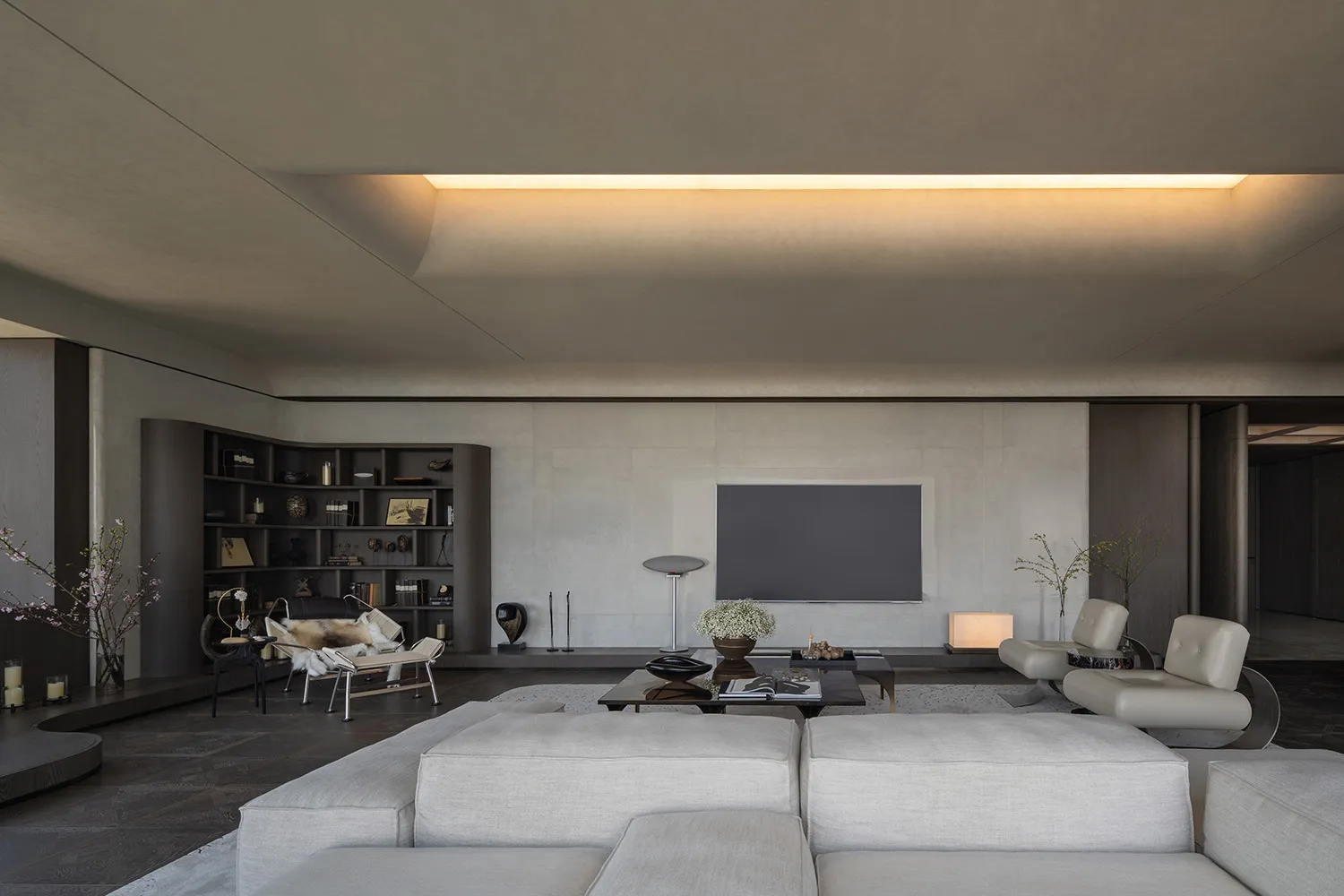 A modern living room with neutral-toned furniture and minimalist design elements.