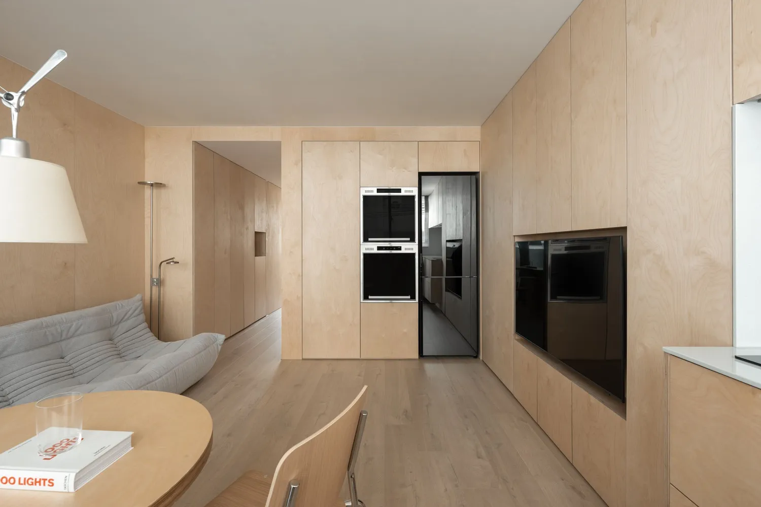 Modern minimalist kitchen featuring wooden cabinets and appliances.