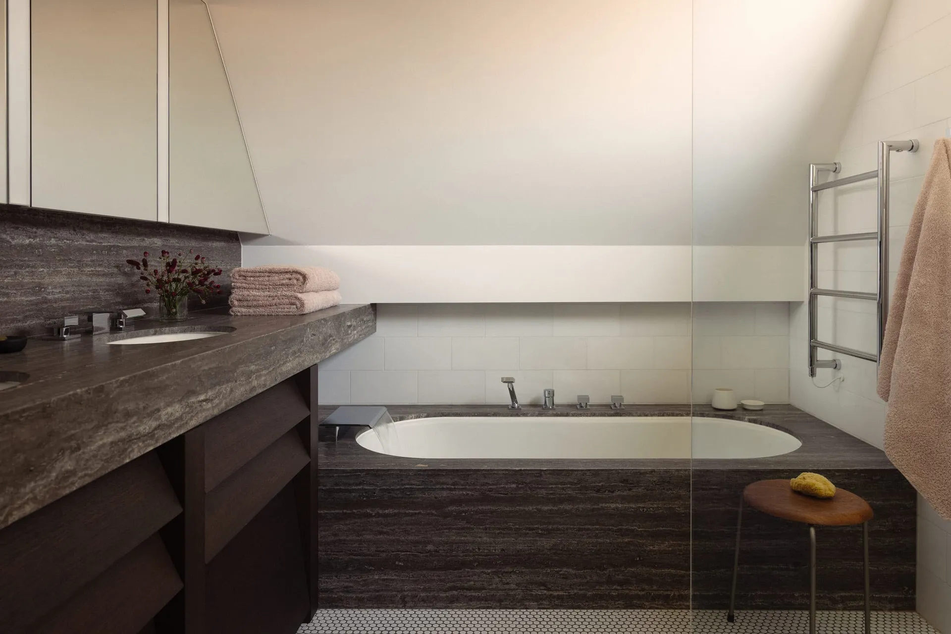 A minimalist modern bathroom with a granite countertop, double sink, and large soaking tub.