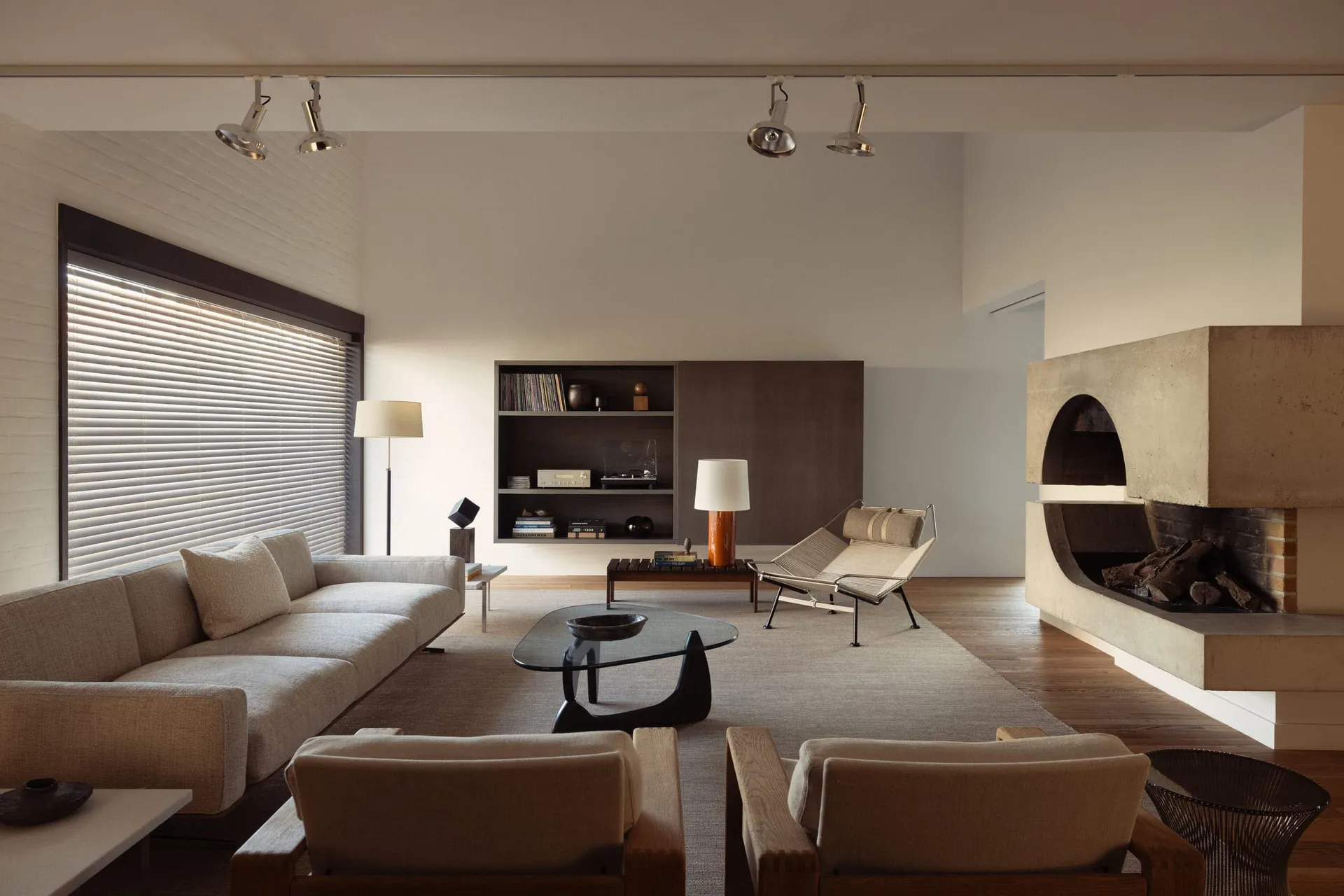 A minimalist living room featuring concrete, wood, and glass materials.