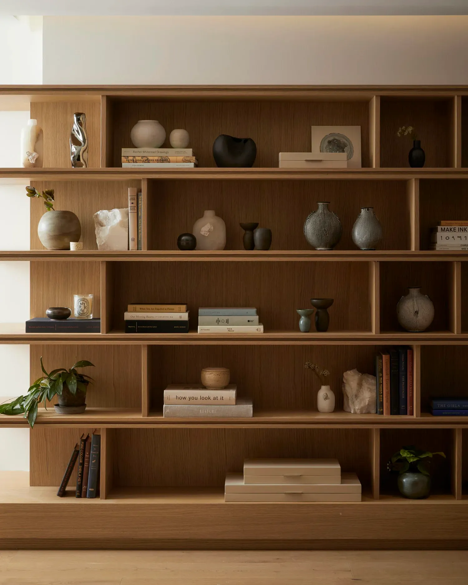 Modern interior shelf featuring a variety of decorative objects and books.