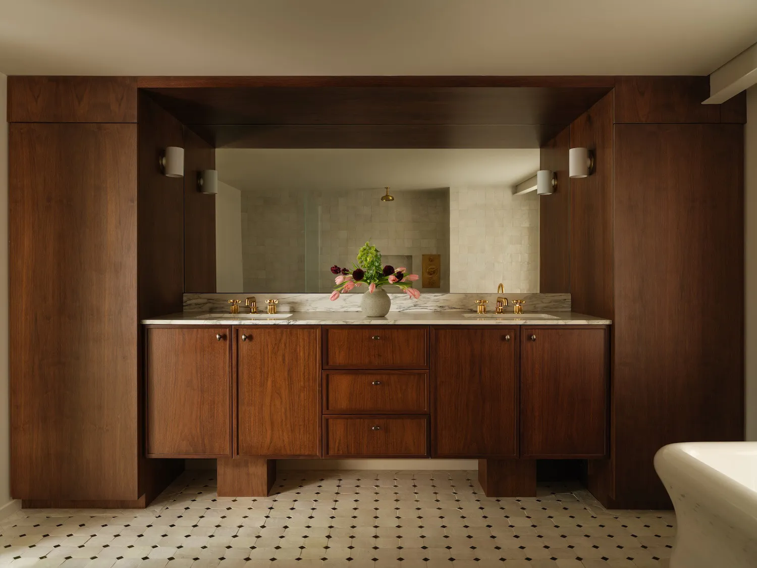 Modern bathroom vanity with wood cabinets, marble countertop, and metal faucets.