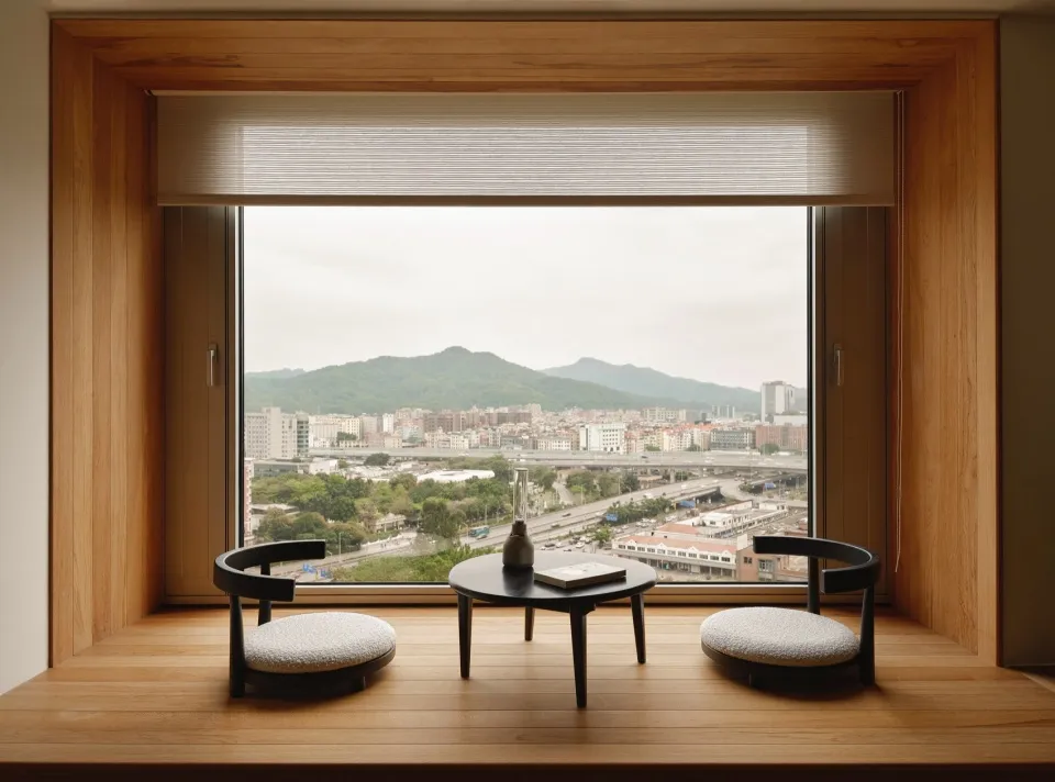 A cozy living room with a modern window overlooking a cityscape.