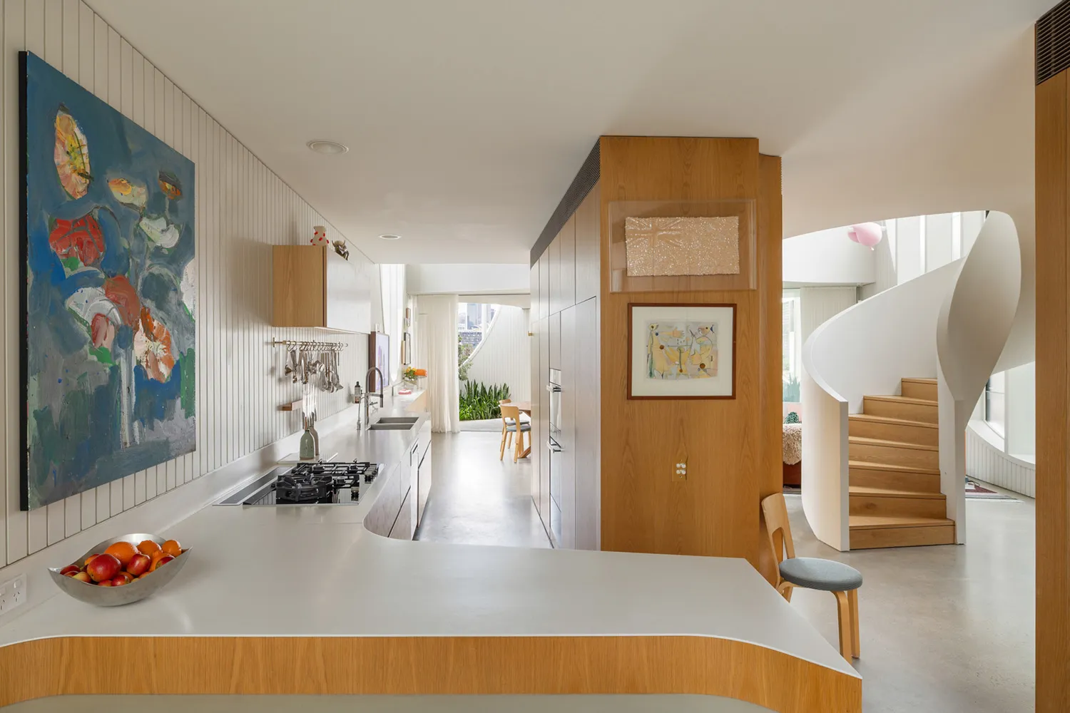 Modern residential kitchen featuring concrete countertops, wooden cabinets, and metal accents.