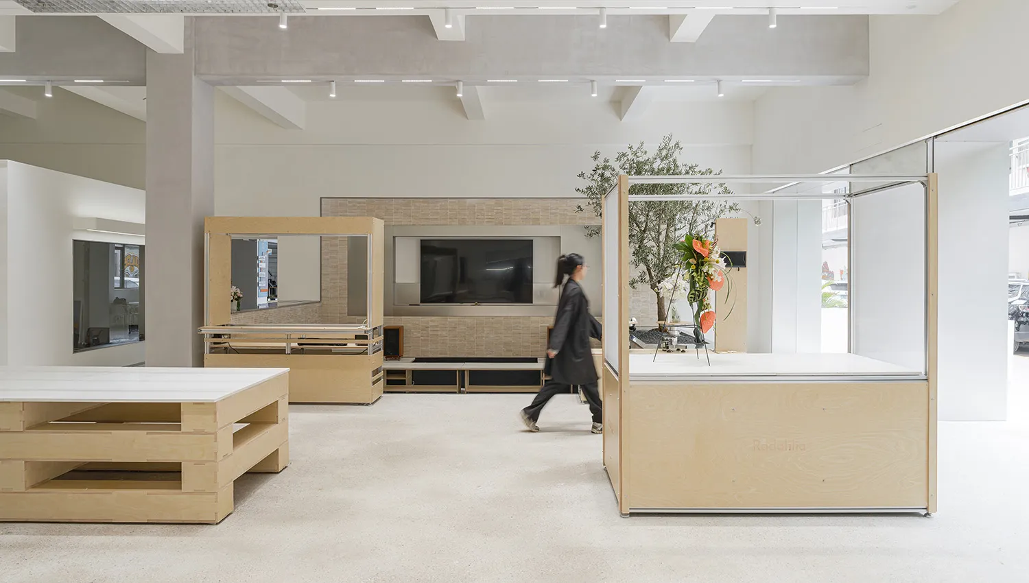 A minimalist retail storefront featuring a modern design with wooden elements and a large display window.