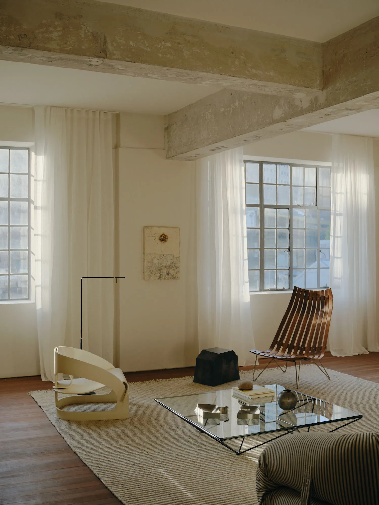 A minimalist living room featuring wood, concrete, and glass materials.