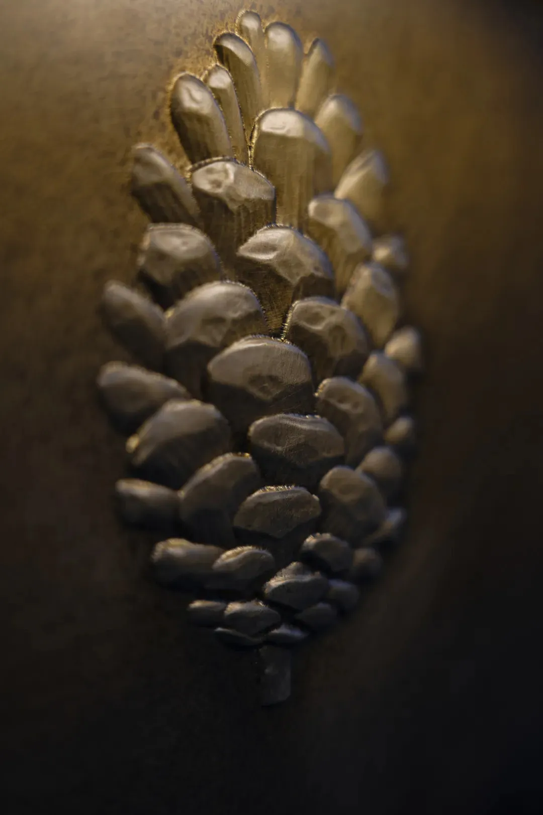 A close-up view of a metallic pine cone decorative element.