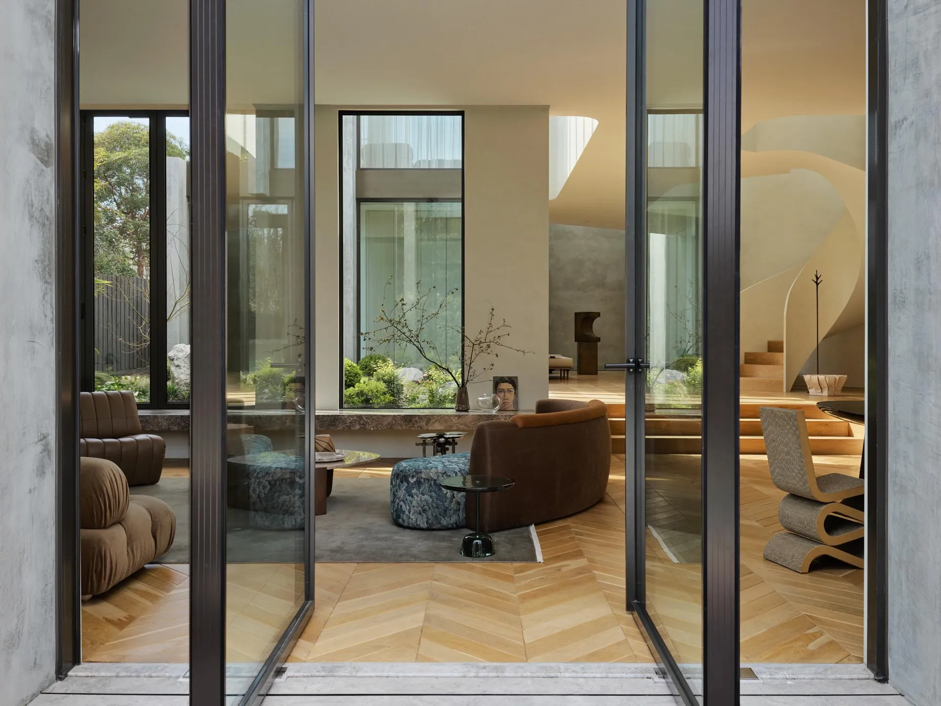 A modern living room with wooden flooring, featuring comfortable seating and a sleek, contemporary design.