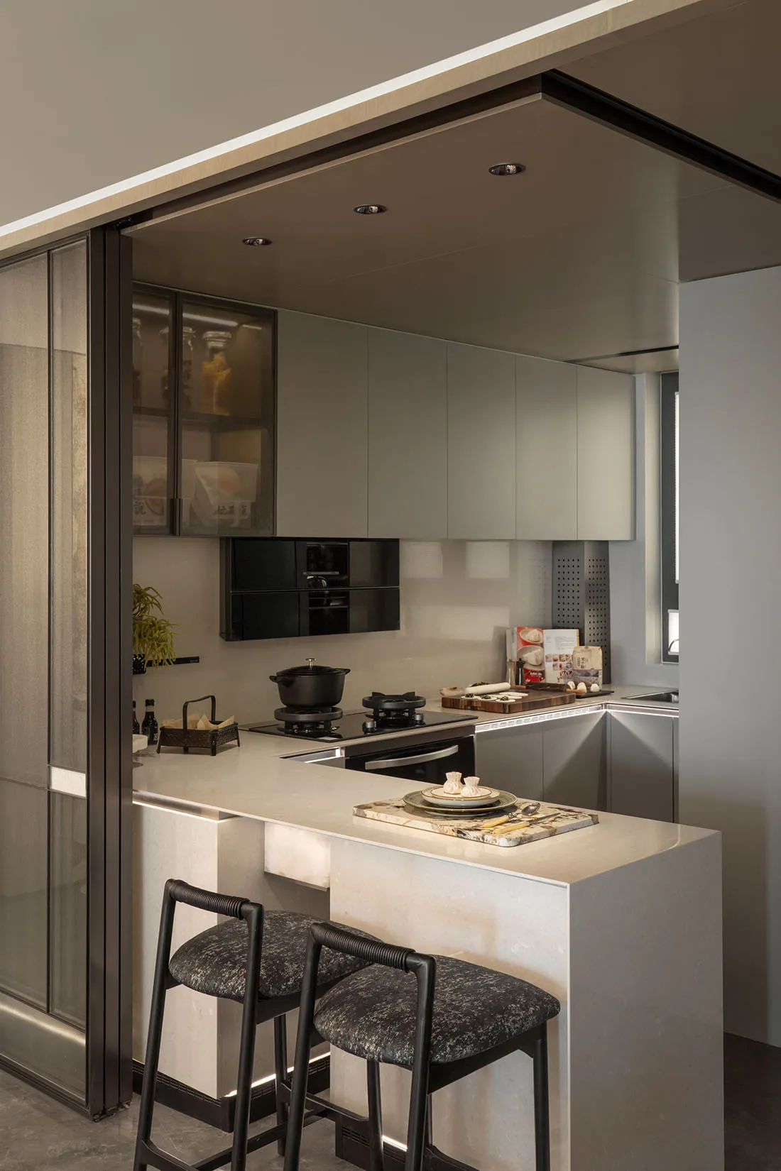 A modern, minimalist kitchen featuring marble countertops and sleek, contemporary cabinetry.