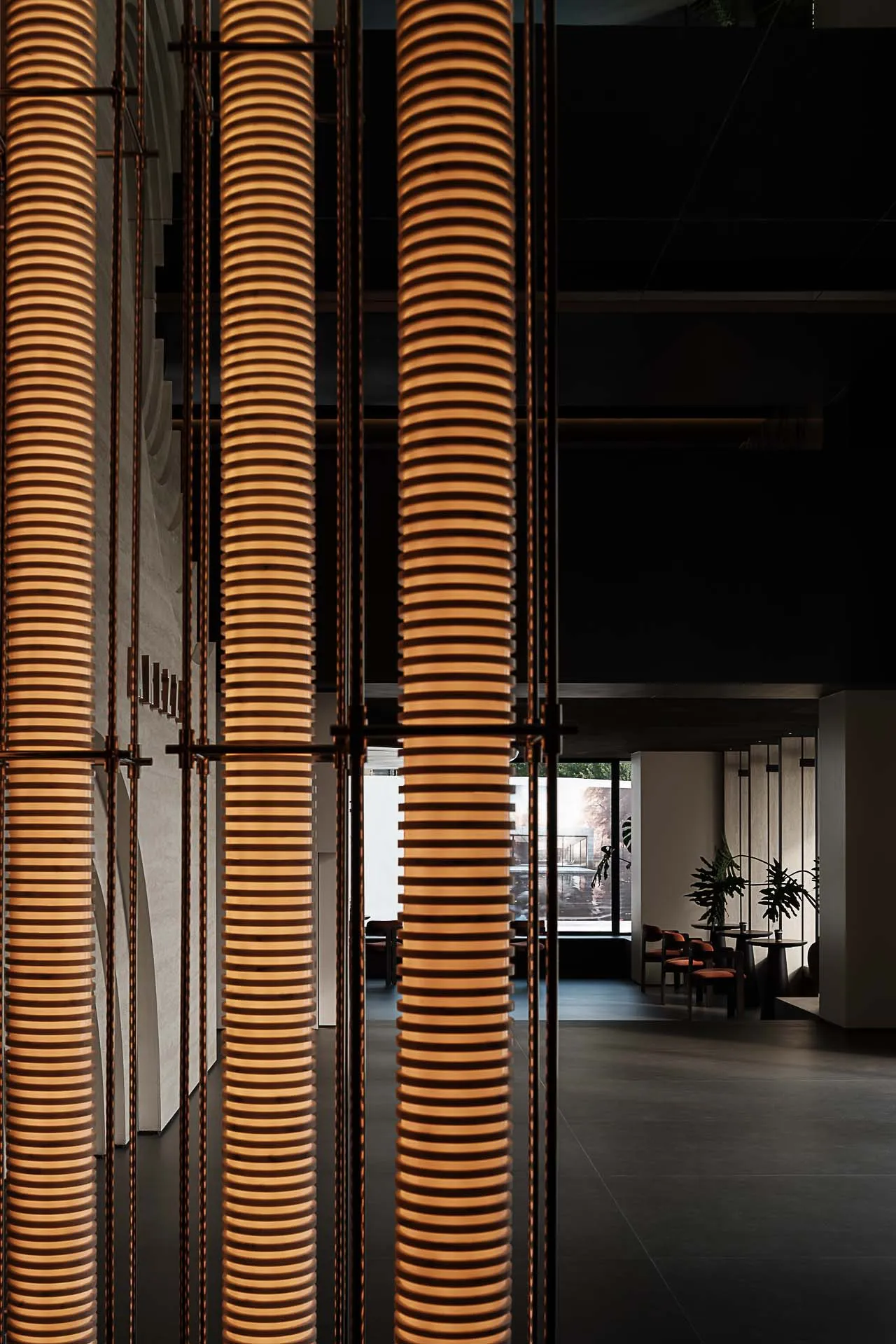 The interior of a modern restaurant featuring glass and metal geometric columns.