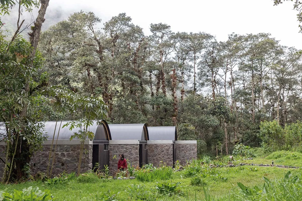 Modern residential exterior with stone finishes amidst greenery.