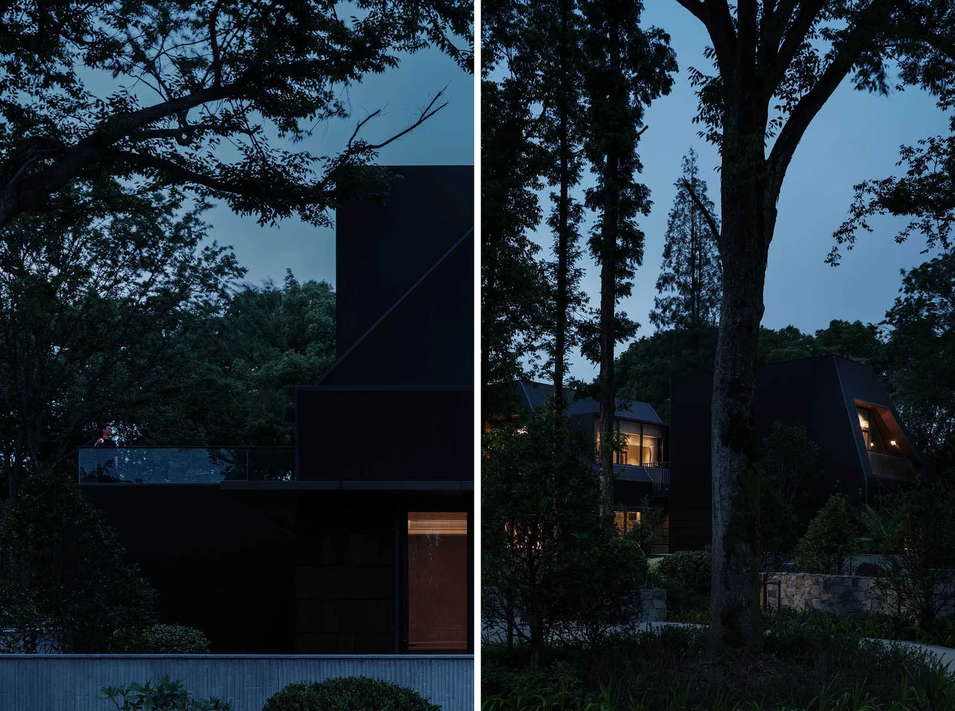A modern house with black exterior walls and metal roof at dusk.