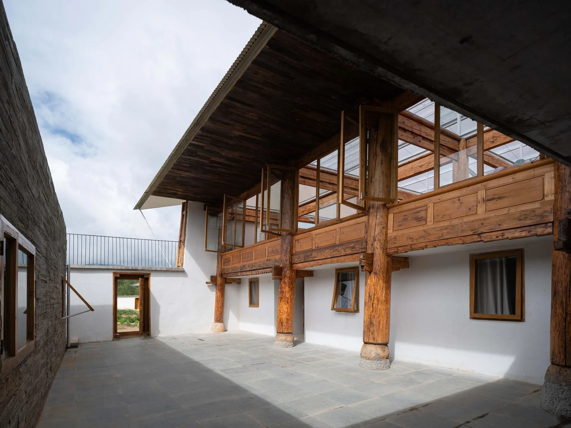 Modern residential exterior with wooden facade and concrete patio area.