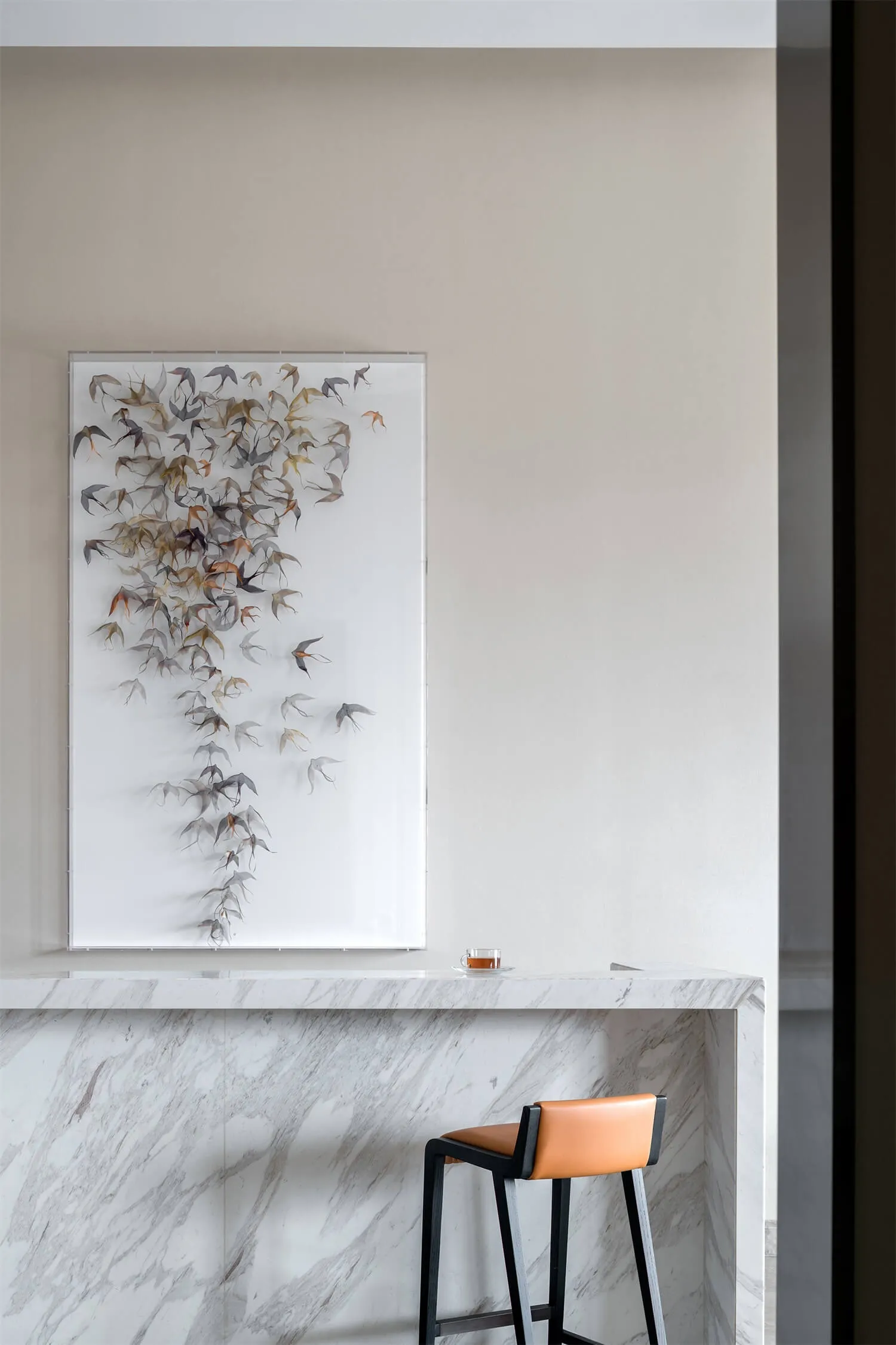 A modern interior design featuring marble materials, with a bird art sculpture and a bar counter.
