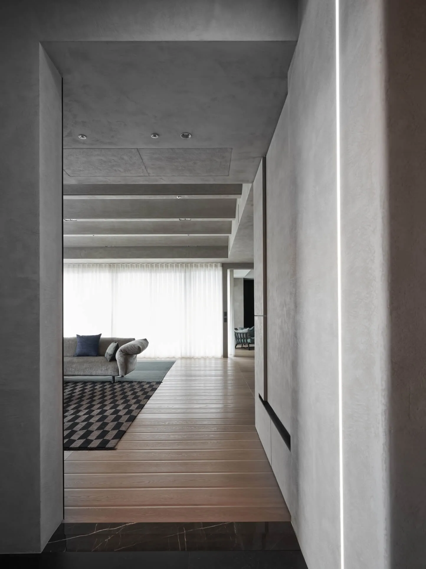 Modern minimalist living room featuring a concrete ceiling, wooden flooring, and glass windows.