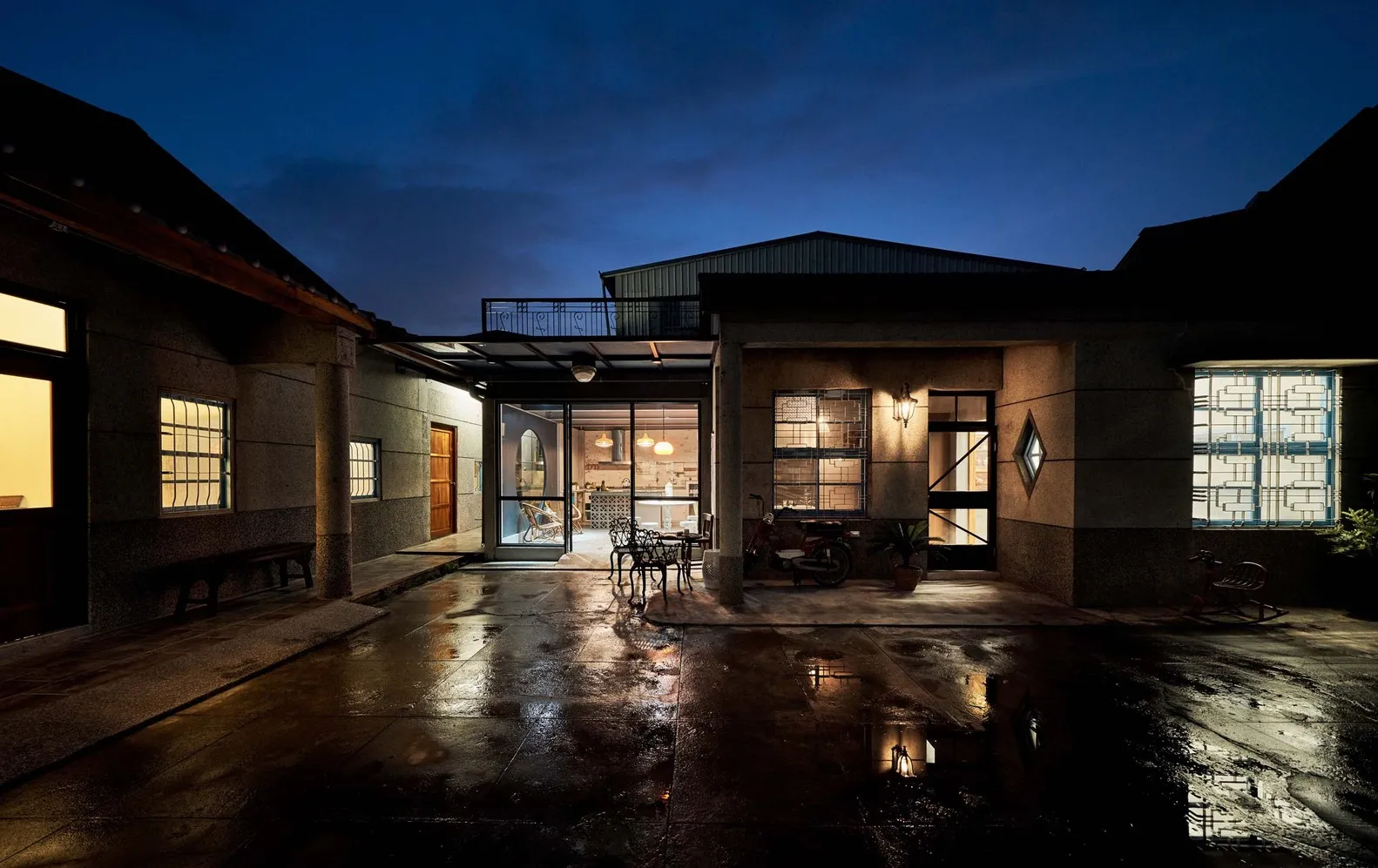 A modern residential property with a concrete yard at dusk.