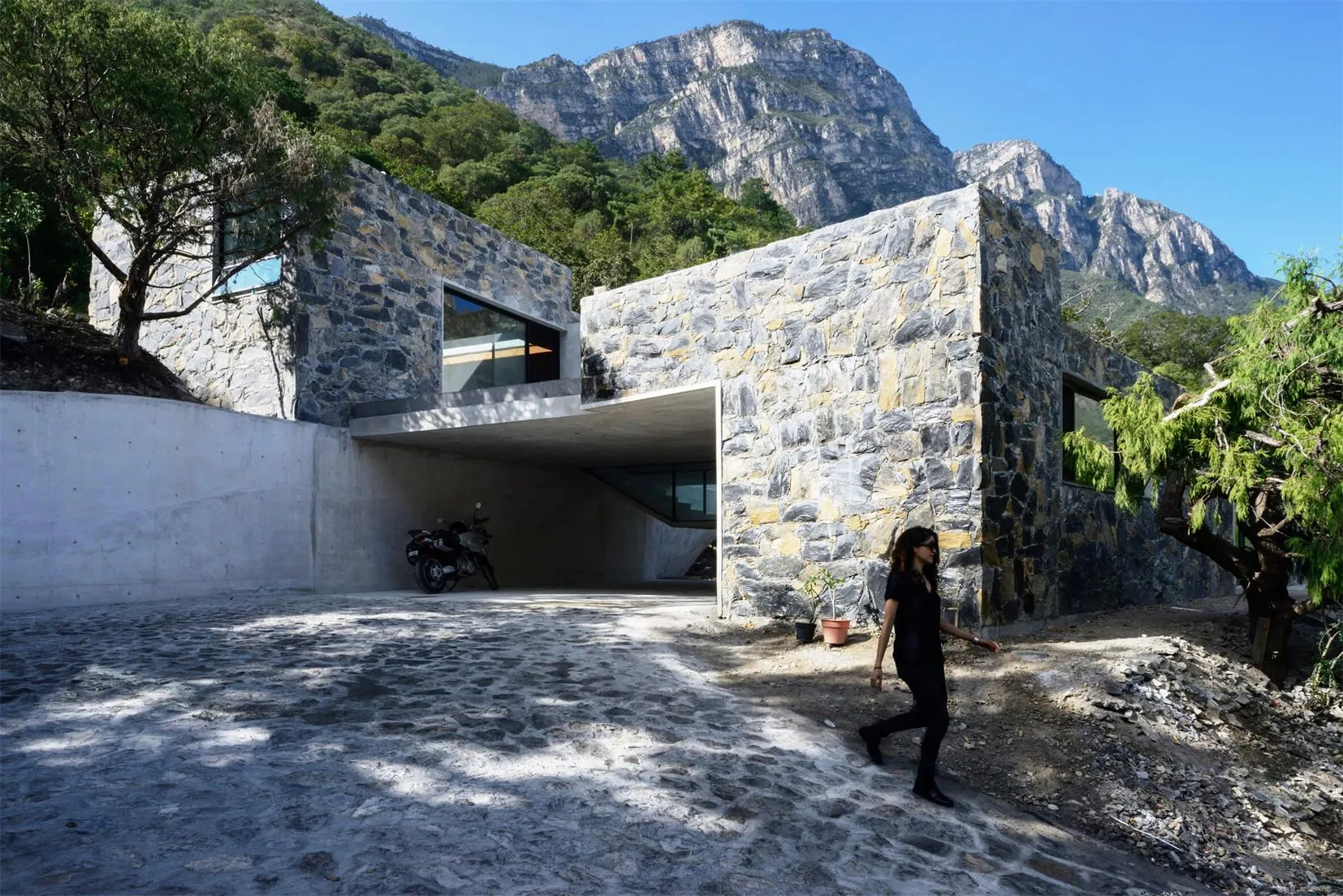 A modern residential home with a stone exterior and concrete entrance.