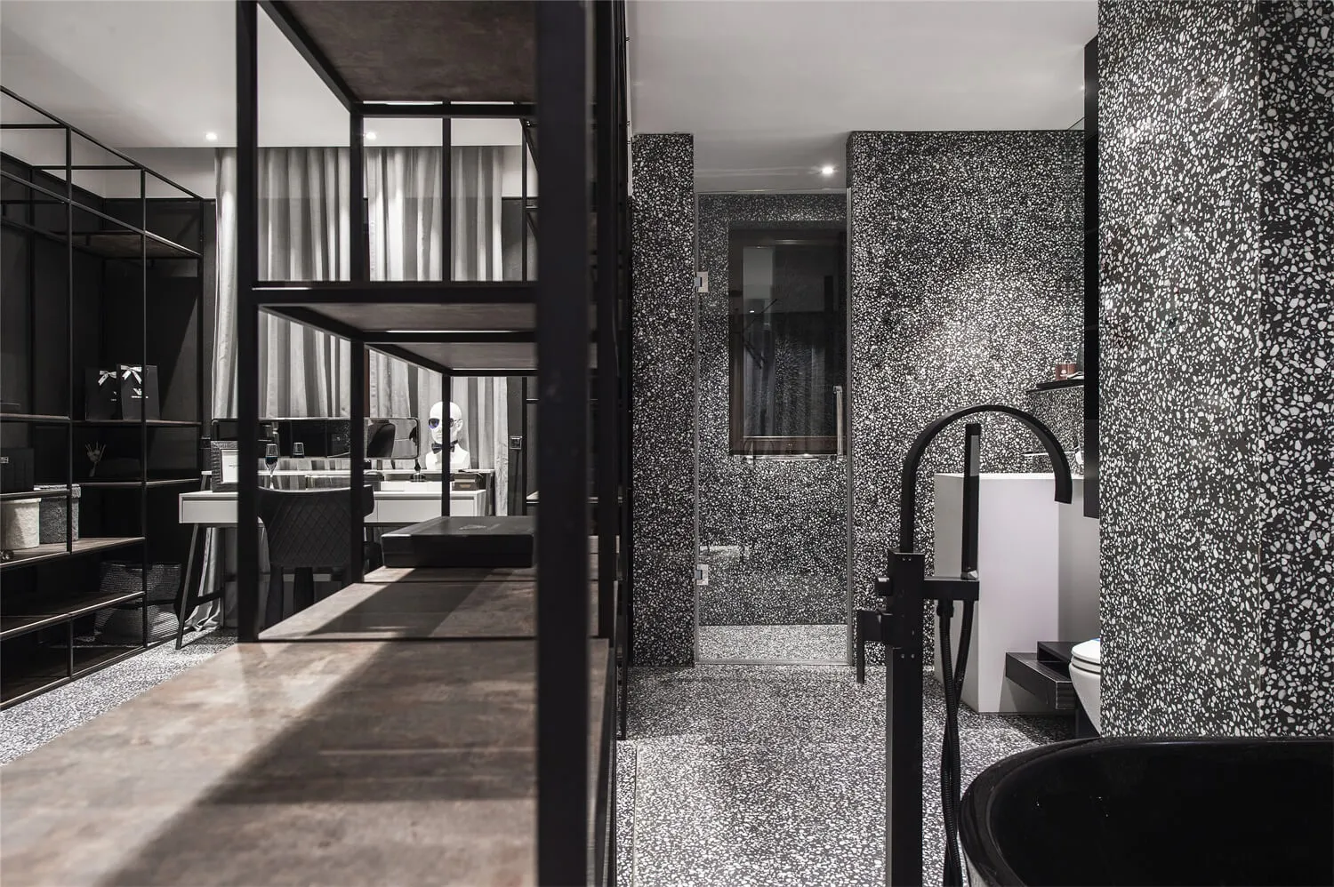 A modern bathroom featuring black and white terrazzo tiles.