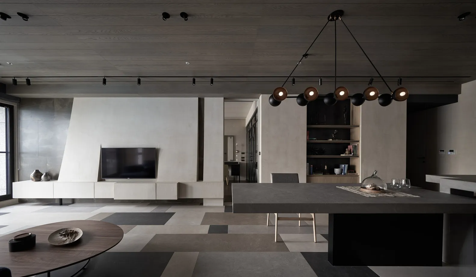 Contemporary minimalist living and dining area with concrete walls and flooring.