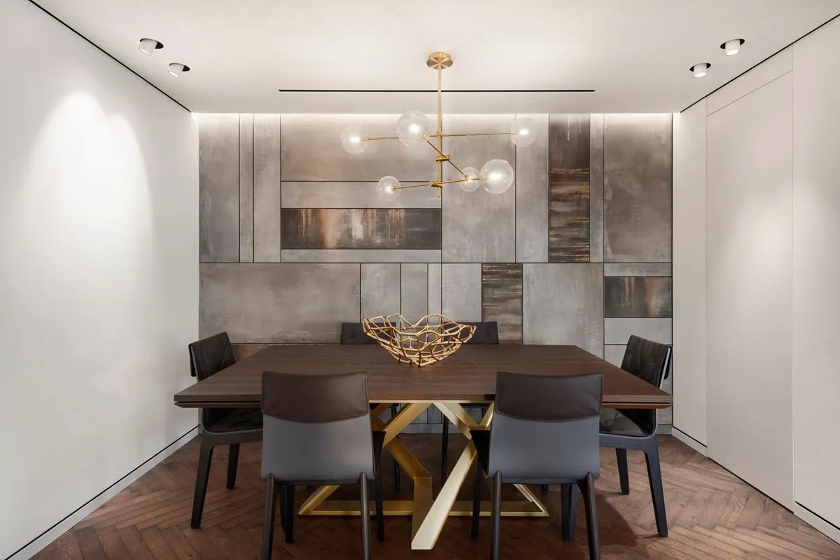 A modern dining room with a metal, wood, and concrete design featuring a wooden table, metal chairs, and a concrete wall.