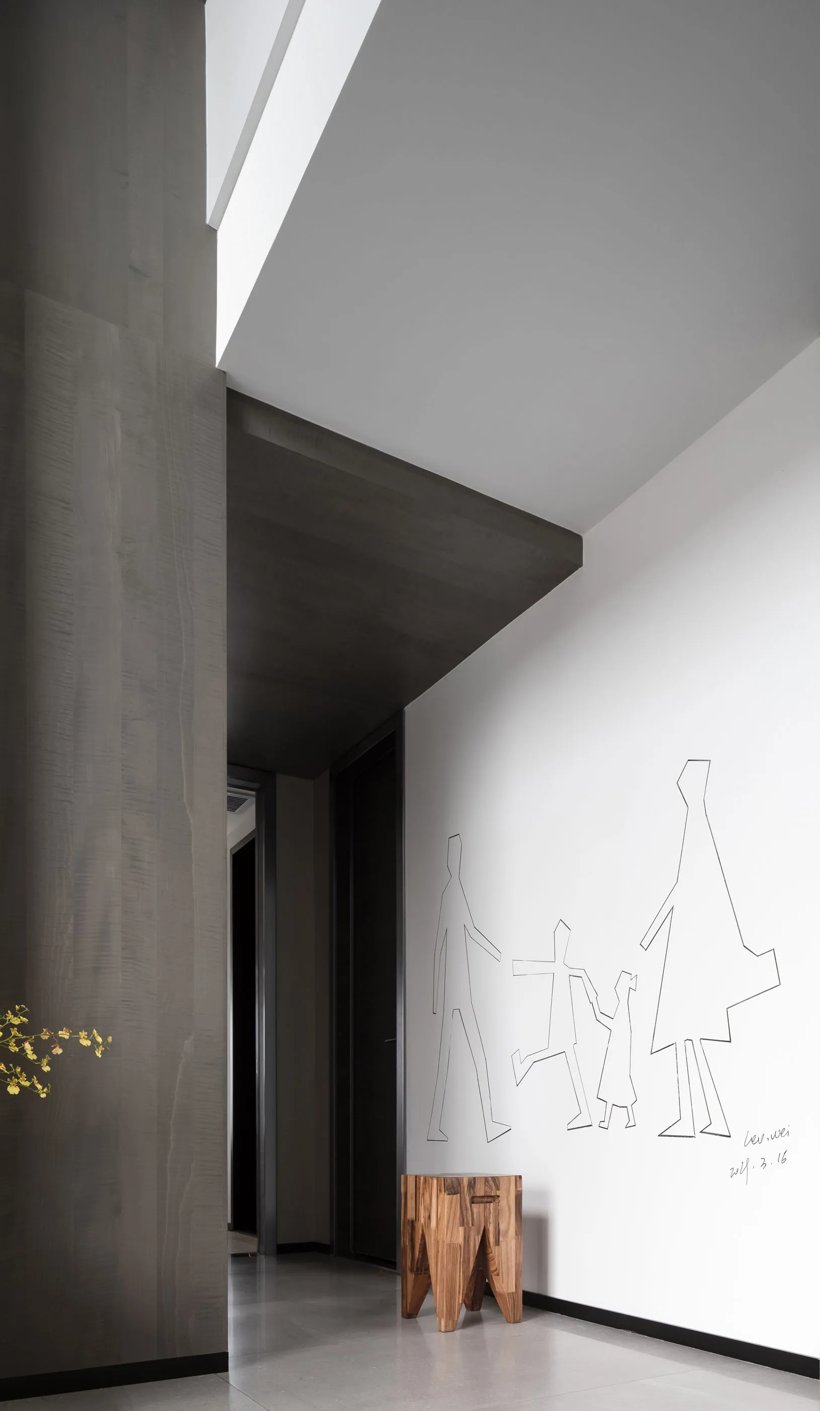 Modern minimalist interior with wooden furniture and a family drawing on the wall.