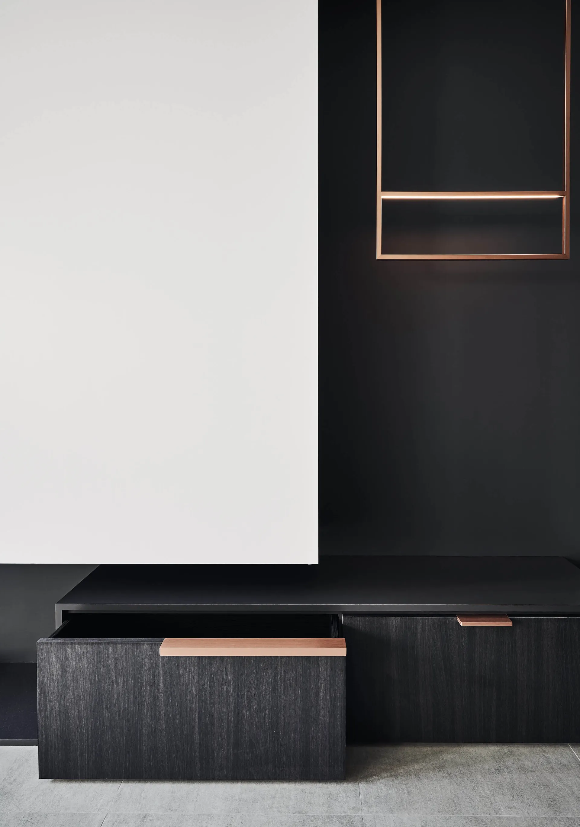 Modern black and white wooden cabinets with open drawers in a minimalist design setting.