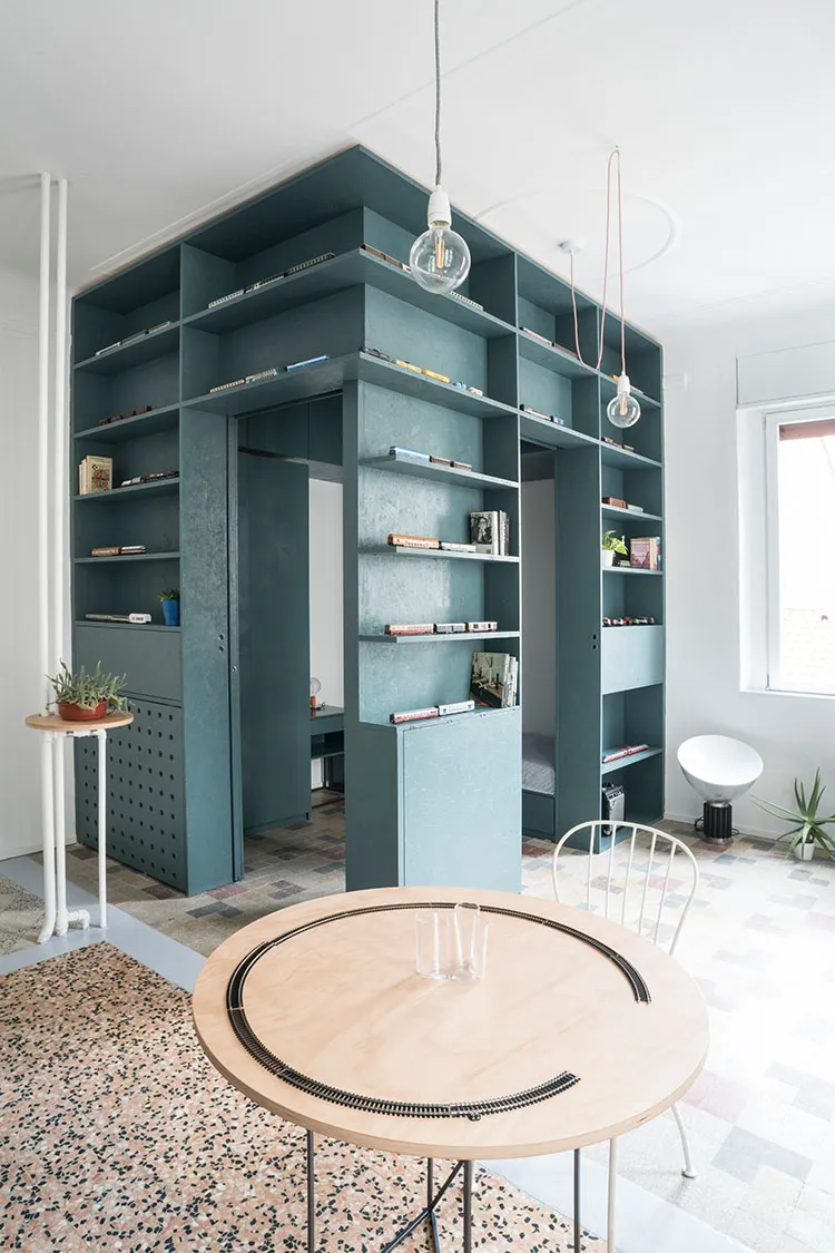 Modern living room with built-in shelving and terrazzo flooring.