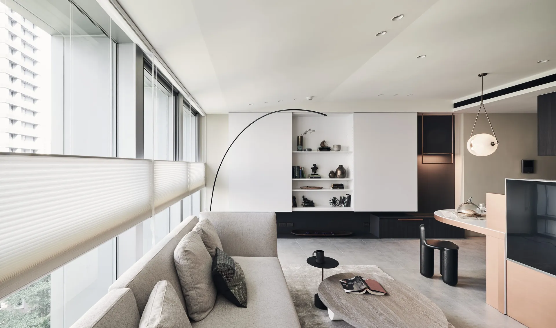 A modern minimalist living room featuring paneled walls and a large floor lamp.