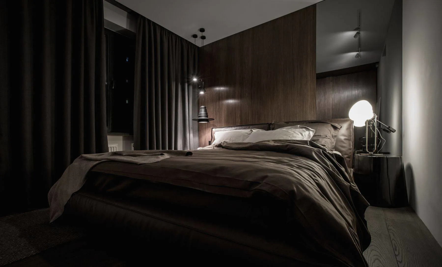 Industrial bedroom featuring dark textiles and minimalist design