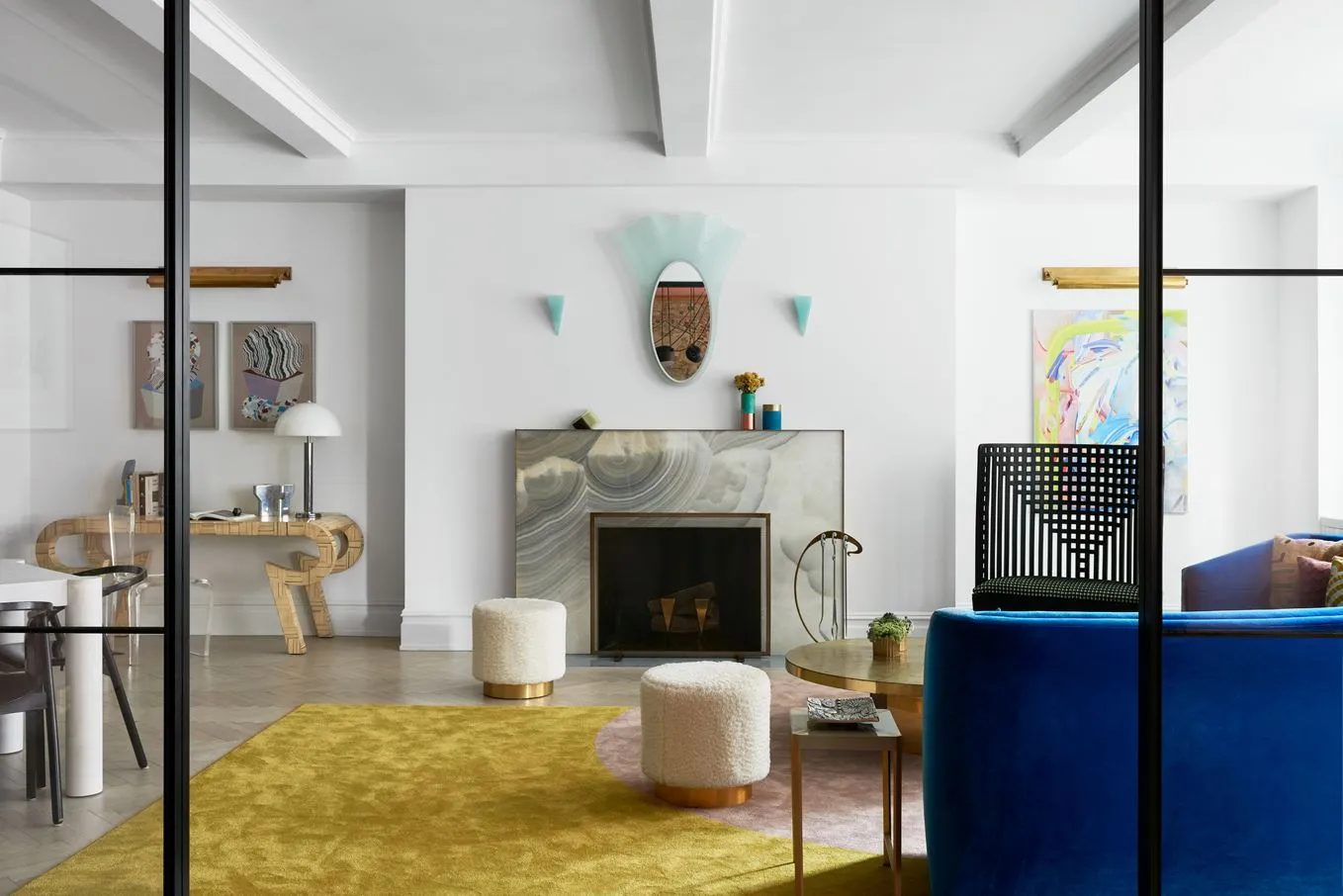 Modern living room featuring a fireplace with a marble mantle and colorful abstract art.