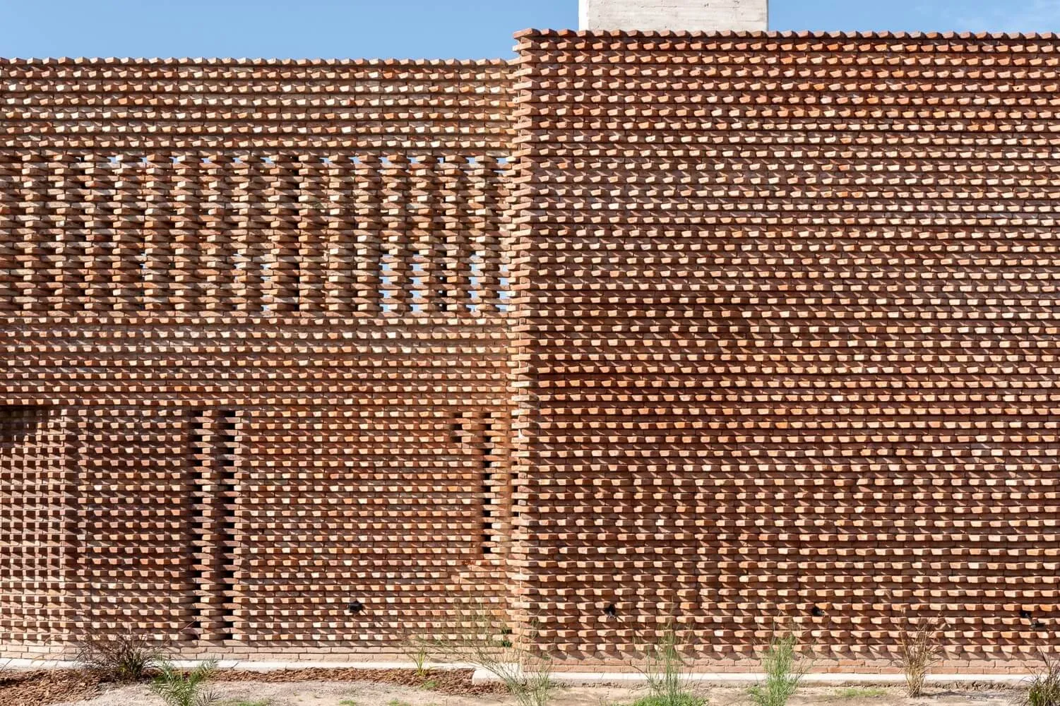 A brick wall with an intricate lattice pattern, featuring a combination of solid and open sections.