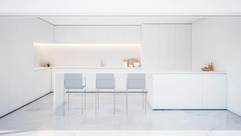 A minimalist white marble kitchen interior with sleek, modern cabinets and a long island.