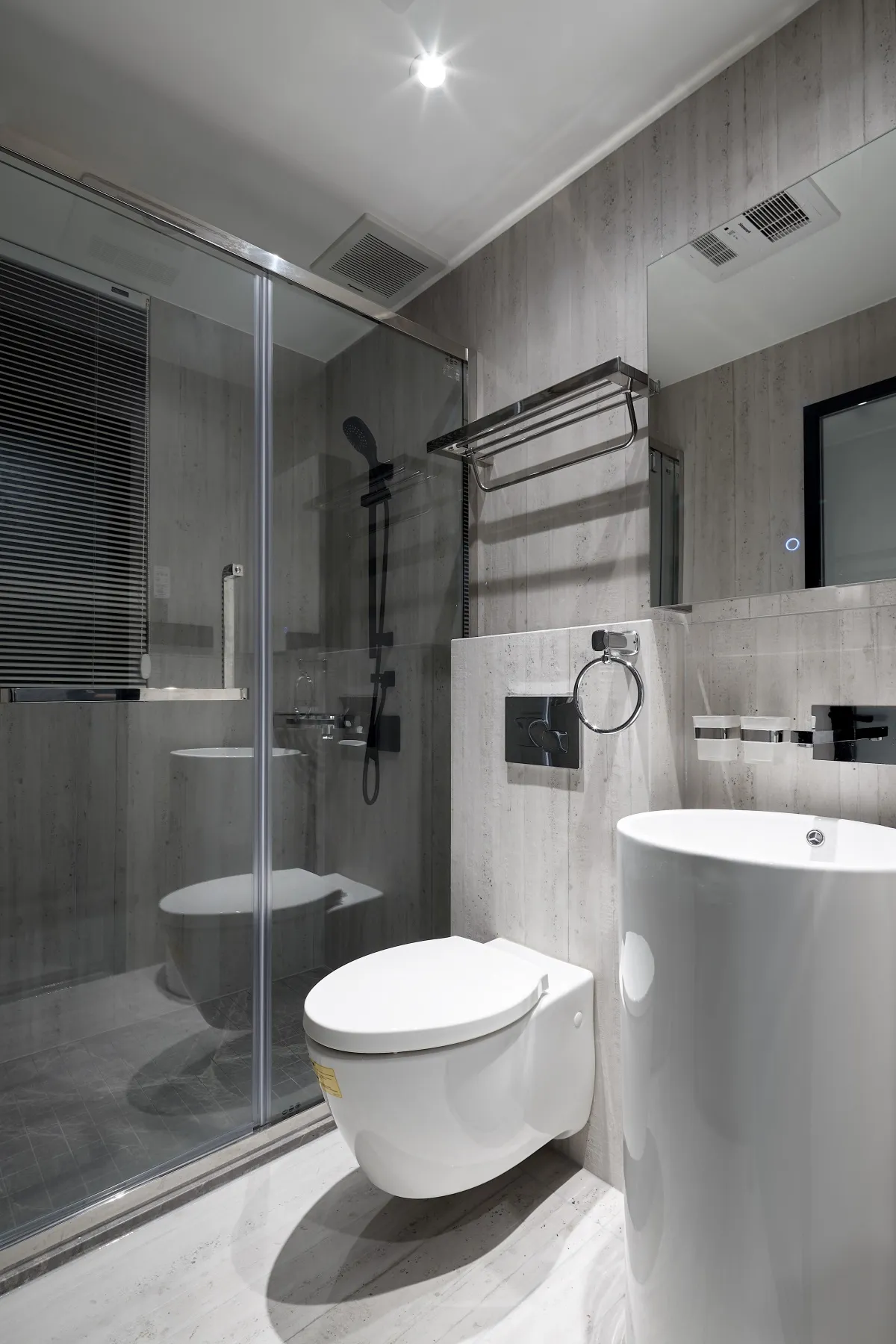 Modern, minimalist bathroom with concrete walls, white fixtures, and glass shower enclosure.