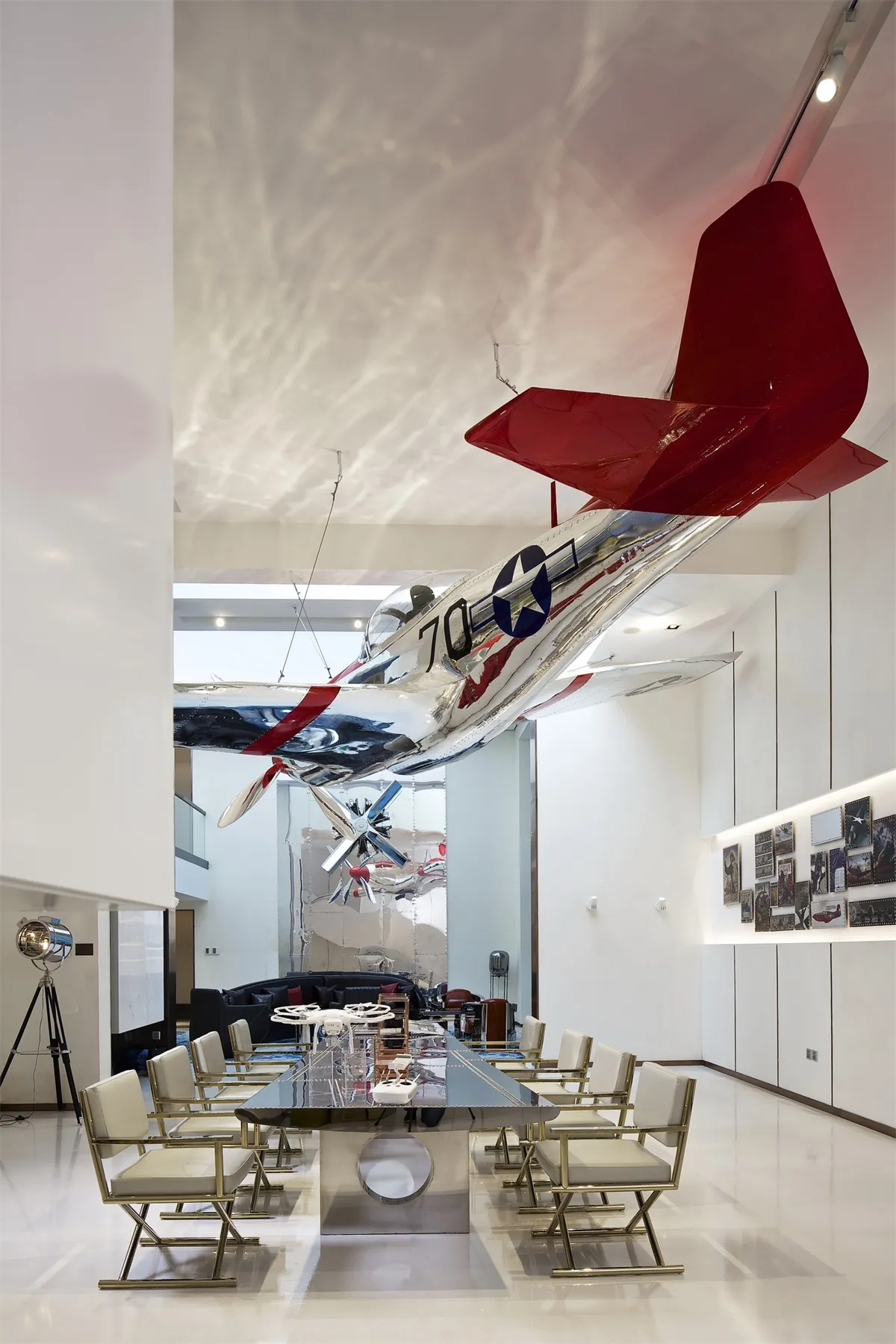 A minimalist office lounge featuring an airplane suspended from the ceiling.
