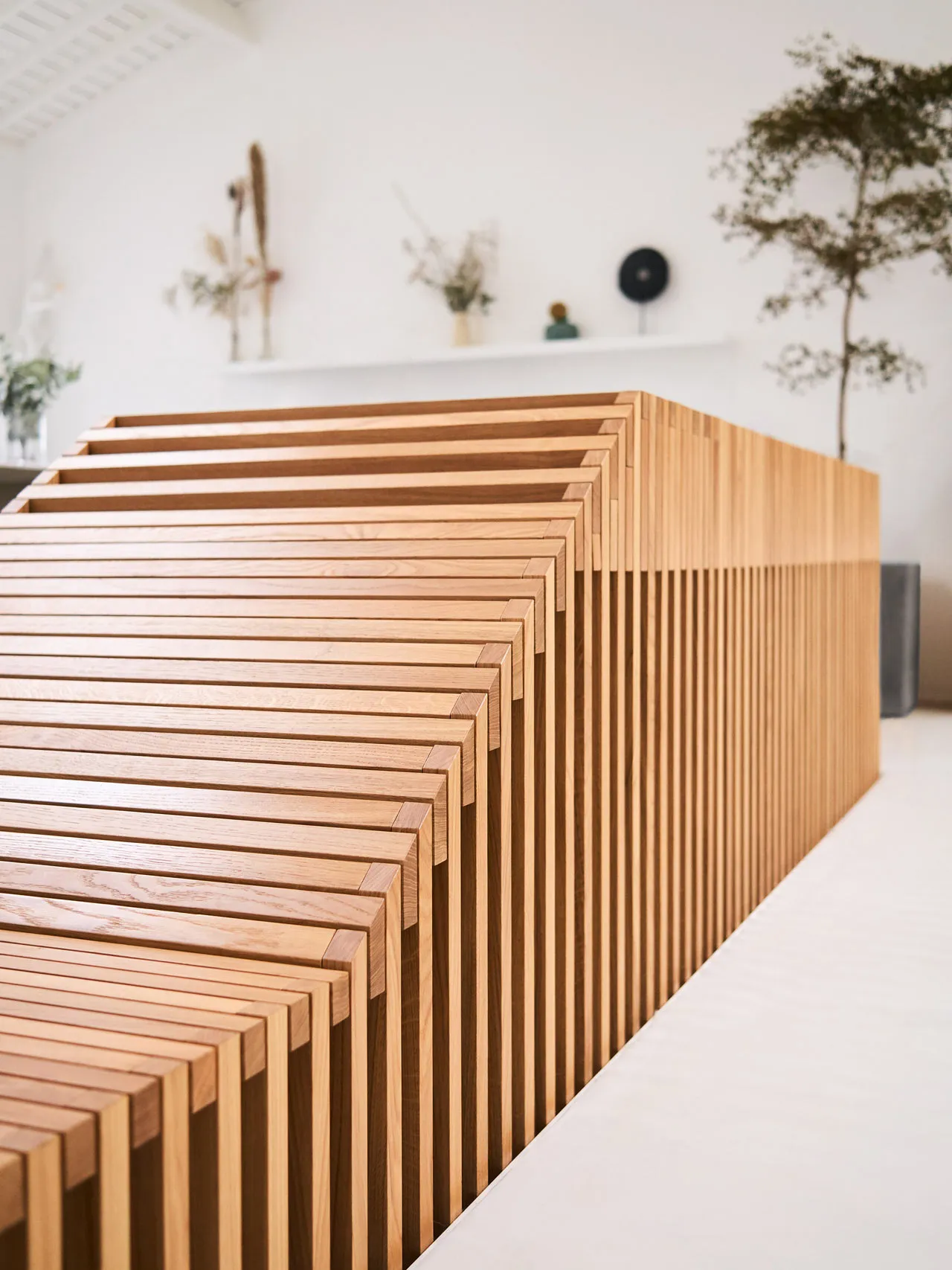 A row of modern, minimalist wooden furniture arranged in a staggered pattern, featuring clean lines and a neutral color palet