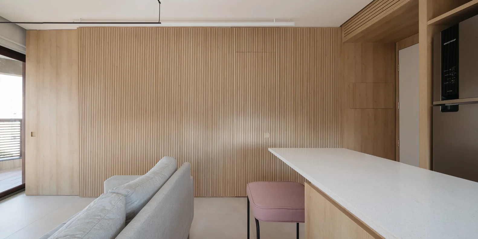 A modern kitchen with wooden panels and a white countertop.