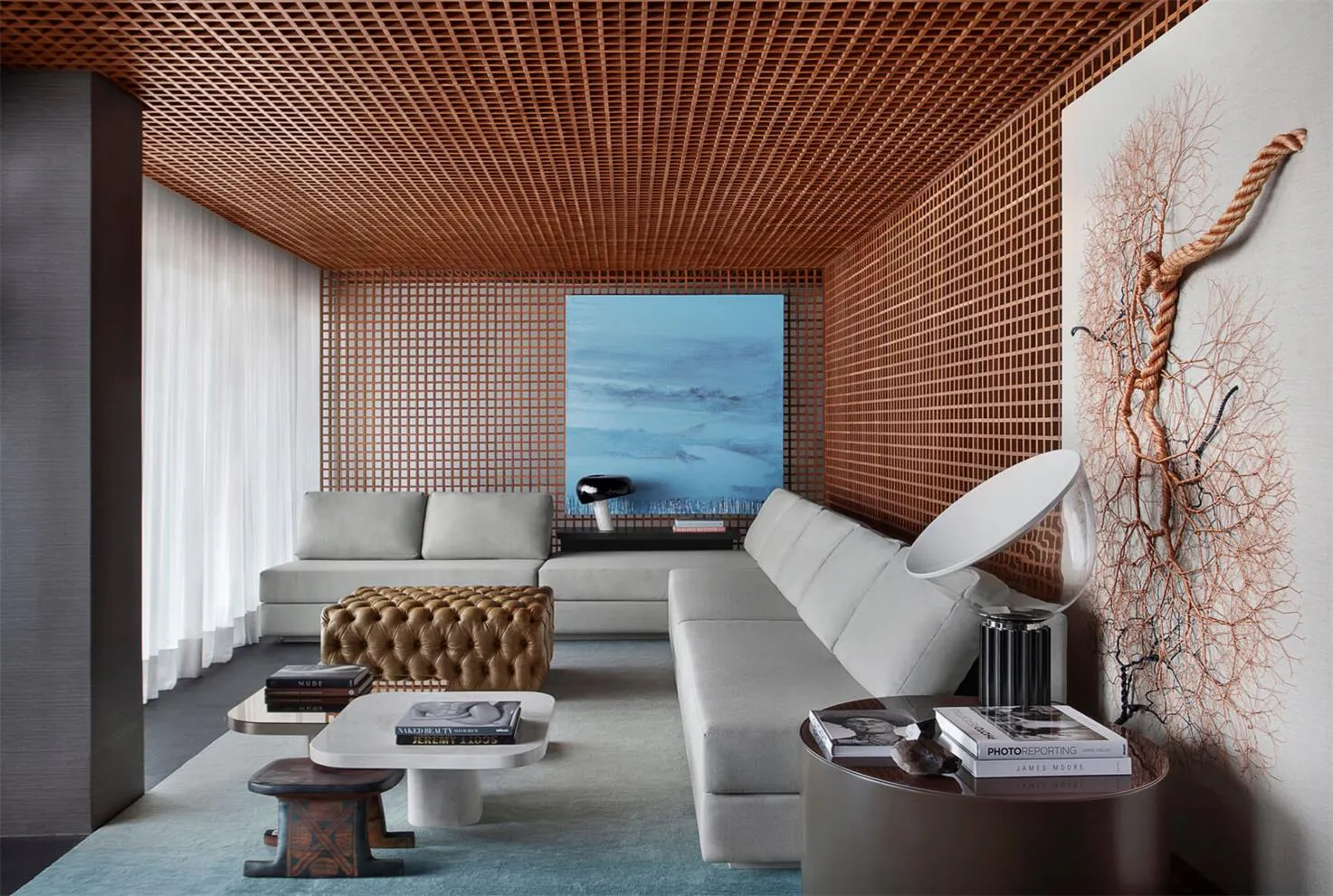 A modern living room with a latticework ceiling and grey sofas.