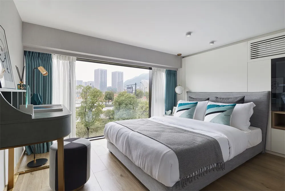 Modern bedroom featuring minimalist design with fabric and glass materials.