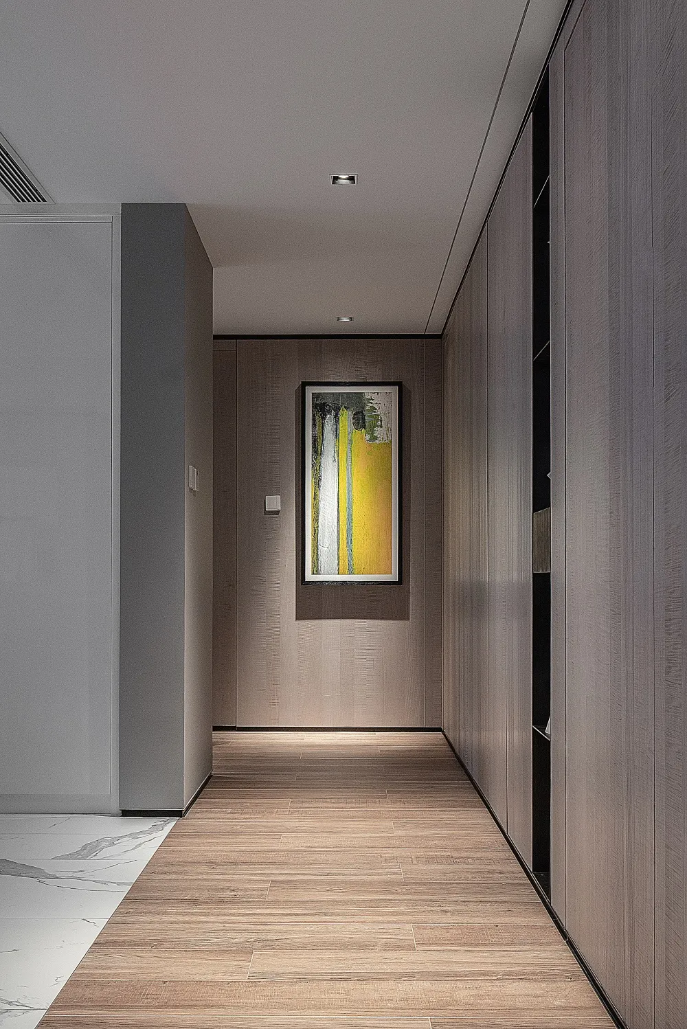 A modern interior corridor featuring wooden flooring and a framed abstract painting on the wall.