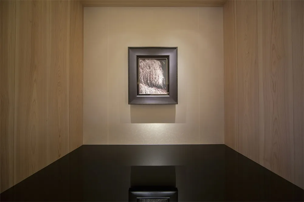Modern interior design featuring a photograph of a minimalist space with wooden walls and a black table.