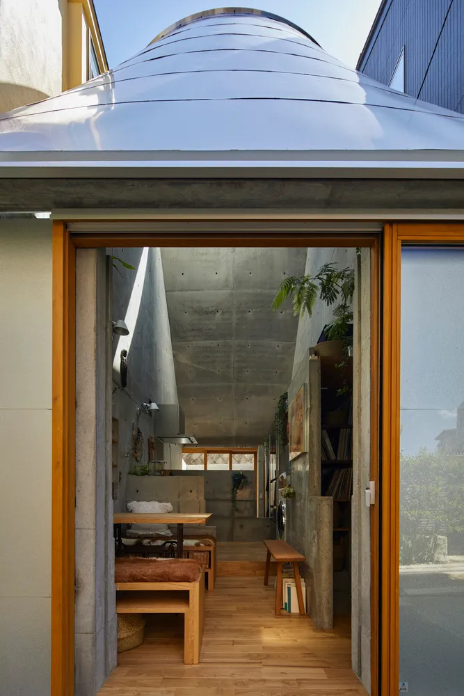 A modern industrial living space featuring exposed concrete ceiling and walls.