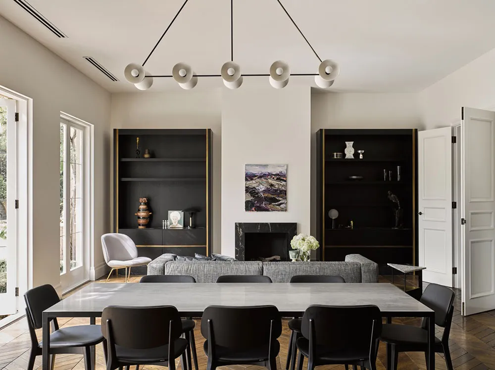 A modern living room featuring concrete decor and minimalist furniture, with large windows and a fireplace.