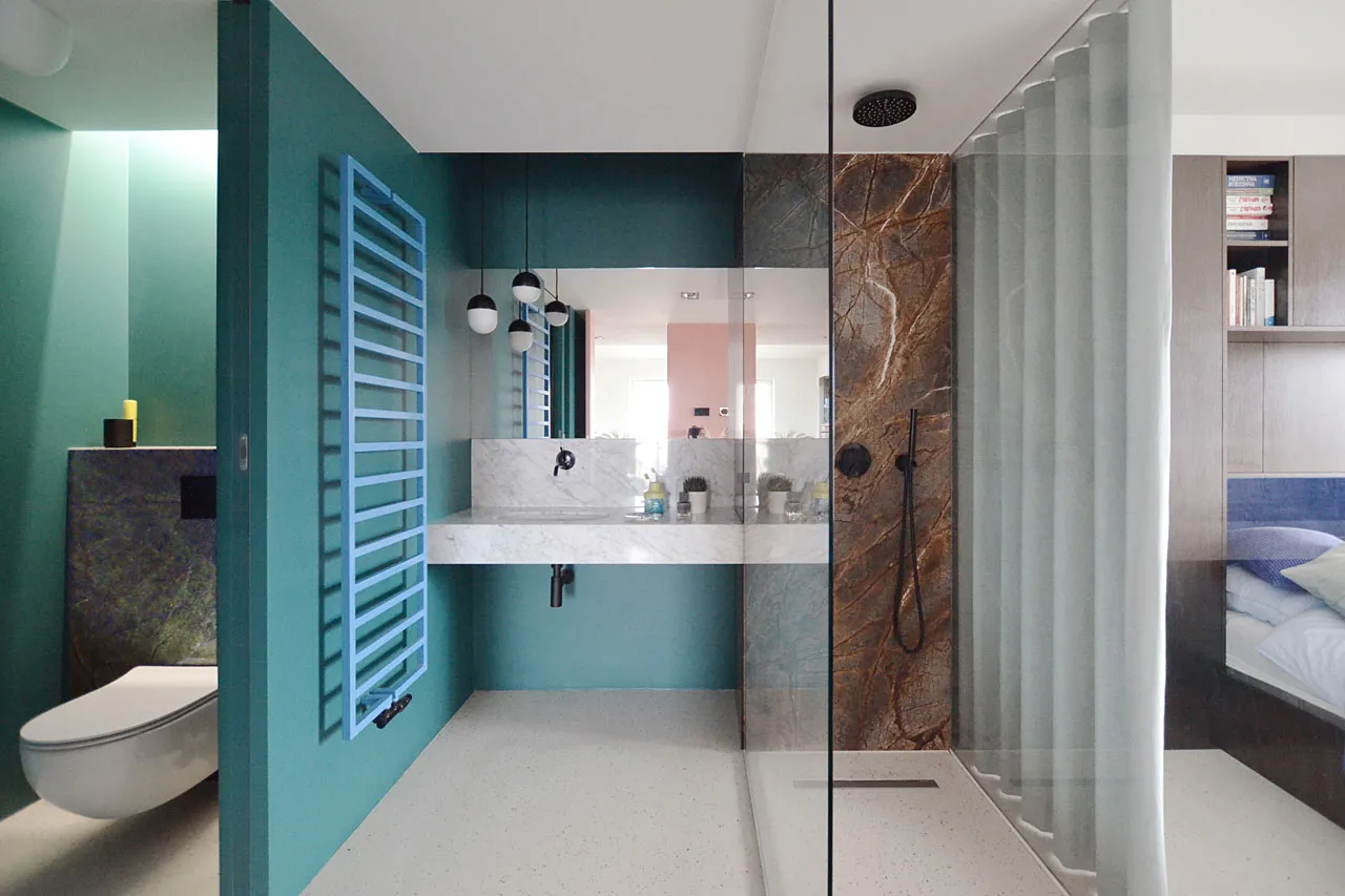 A modern minimalist bathroom with marble accents and a white floor.
