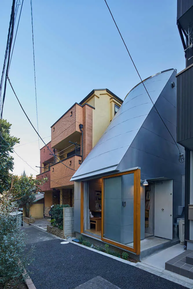 現代住宅外觀採用金屬覆層設計，搭配大型窗戶與弧形屋頂。