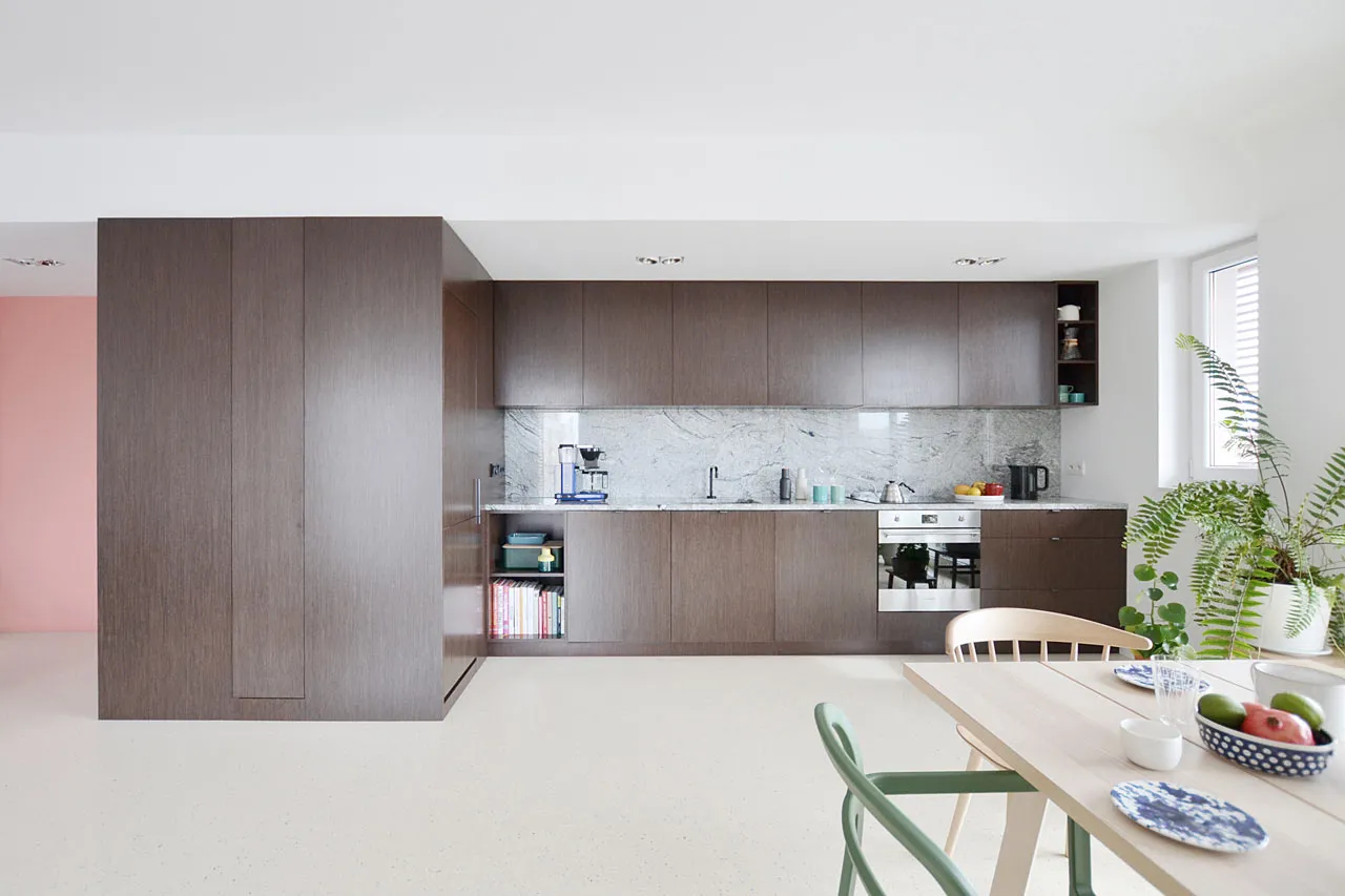 A contemporary kitchen with dark wood cabinets and a marble countertop.