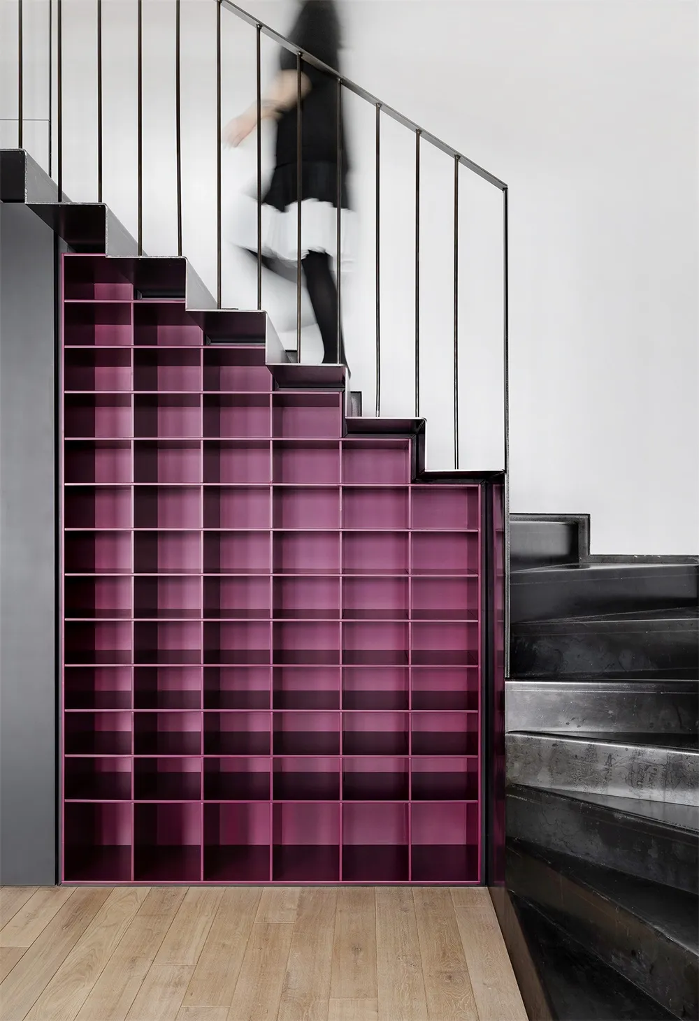 A modern staircase with built-in metal shelving units.