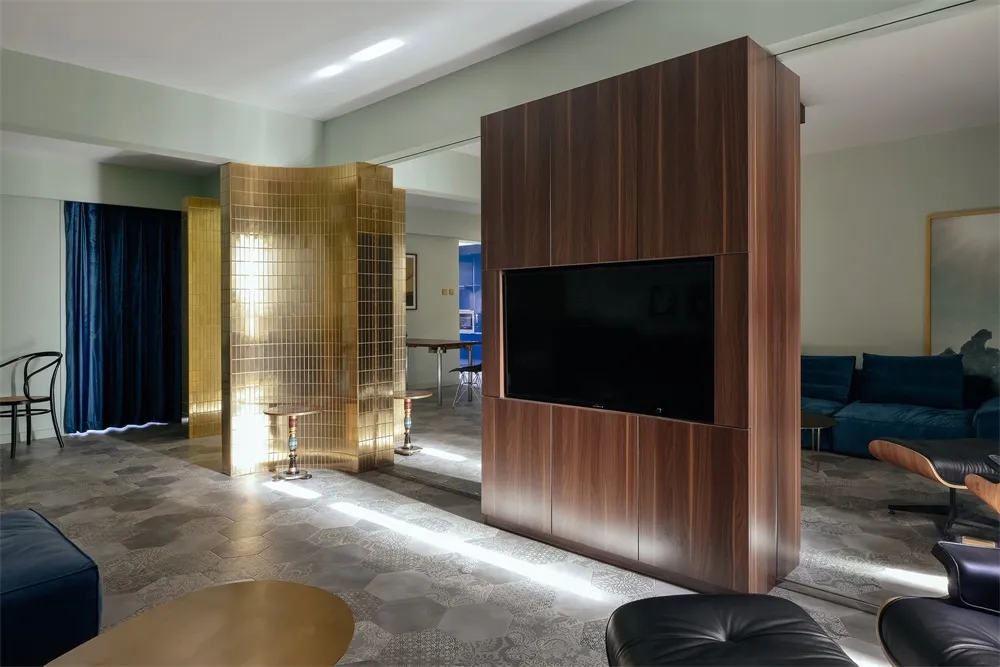 A modern residential living room featuring gold metallic partitions and wooden cabinets.